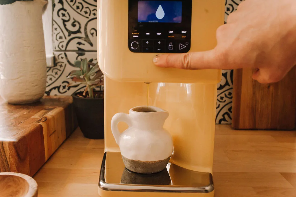 The LĒVO II+ control panel showing the dry, activate and infuse buttons while oil dispenses
